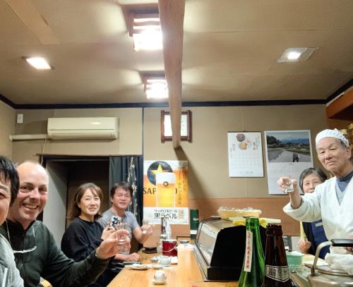 a group of people sitting around a table drinking wine at B&B MIKAWA 5 - Villas with BBQ Terrace in Kanazawa
