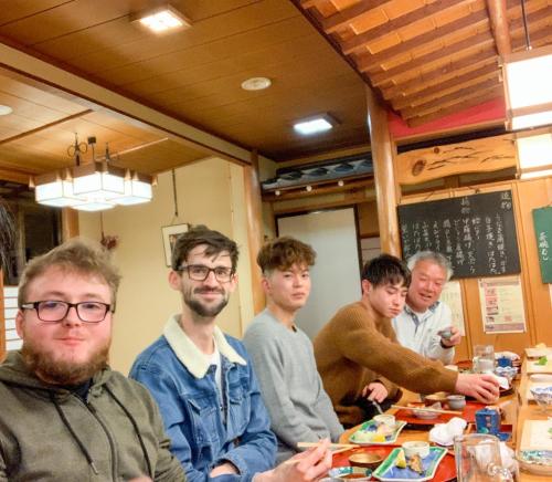 a group of men sitting at a table in a restaurant at B&B MIKAWA 5 - Villas with BBQ Terrace in Kanazawa