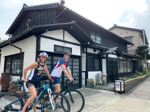 two people on bikes in front of a building at B&B MIKAWA 5 - Villas with BBQ Terrace in Kanazawa