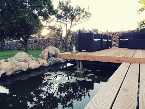 a wooden deck with a pond in a yard at Giardino D'Oriente in Otranto