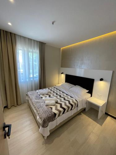 a bedroom with a large bed and a large window at Grand Agia Triada in Agia Triada