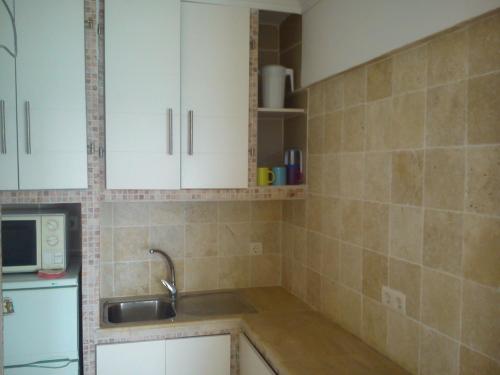 a kitchen with white cabinets and a sink at Estudio sol y playa in Algarrobo-Costa