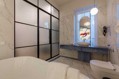 La salle de bains est pourvue de toilettes, d'un lavabo et d'un miroir. dans l'établissement Mola Mola Apart Hotel, à Lviv