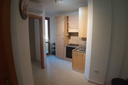 a kitchen with white cabinets and a stove top oven at Casetta Emma, trilocale Elmas, areoporto elegante silenzioso in Elmas