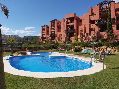 una gran piscina frente a un edificio en Große Ferienwohnung , Spanien, Andalusien, Costa del Sol mit Pool, en San Luis de Sabinillas