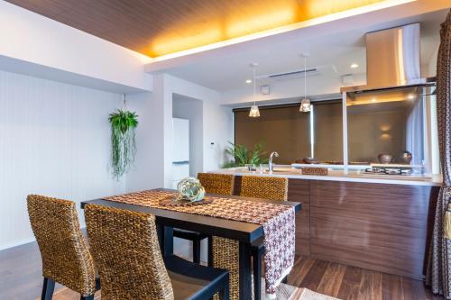 a kitchen and dining room with a table and chairs at Rizo Zaizen Hotel in Ginowan