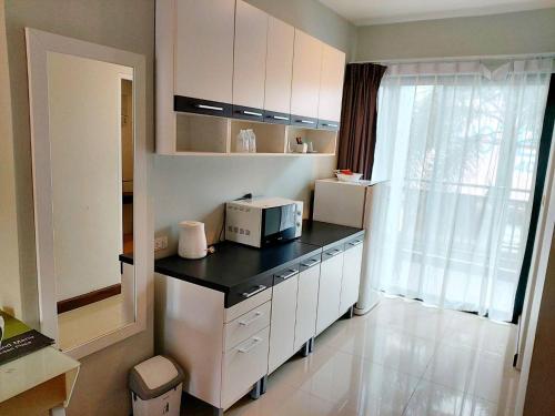 a kitchen with a counter with a microwave on it at Romyen Garden Place in Nakhon Ratchasima