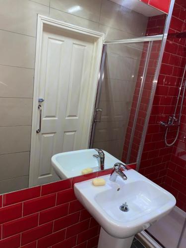 a bathroom with a sink and a red brick wall at Cathedral Hotels Norwich in Norwich