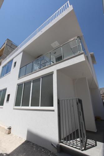 a white building with a gate in front of it at Deda Apartments in Sarandë