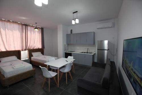 a kitchen and living room with a table and a couch at Deda Apartments in Sarandë
