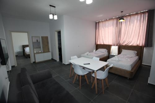 a room with a bed and a table and chairs at Deda Apartments in Sarandë