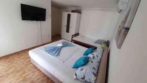 a bedroom with a large white bed with blue pillows at Apartmani Batinović - Baška Voda in Baška Voda
