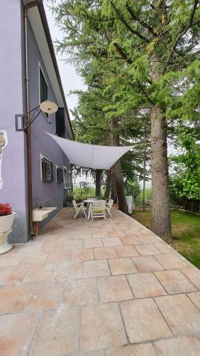 a patio with a white covering on the side of a house at Flamignano relax e natura in Tossicia