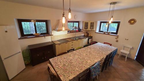 eine Küche mit einem Tisch und einer Arbeitsplatte in der Unterkunft Flamignano relax e natura in Tossicia