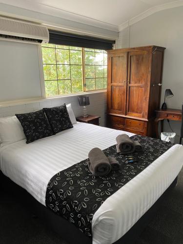 a bedroom with a large bed with towels on it at The Old Convent Dalwallinu in Dalwallinu