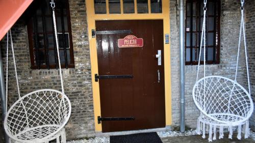 two swinging chairs sitting in front of a door at De Gusto in Schiedam