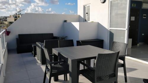 uma mesa preta e cadeiras numa varanda em Sea View Penthouse with large terrace IROM1-1 em Marsaskala