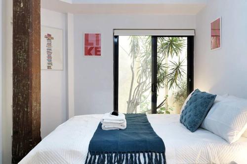 Schlafzimmer mit einem weißen Bett und einem Fenster in der Unterkunft Underwater Oasis Freo - 2BRM with Courtyard & 1 Car Bay in Fremantle