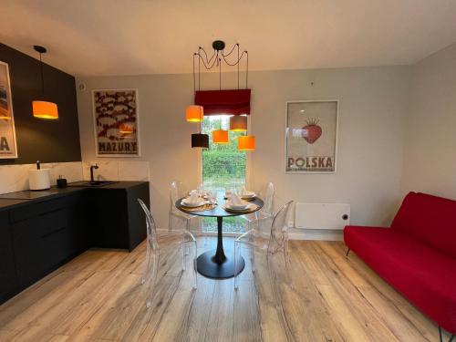 ein Wohnzimmer mit einem Tisch und einem roten Sofa in der Unterkunft Orzyny Summer House in Orzyny