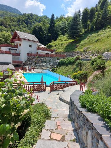 un complexe avec 2 piscines sur une colline dans l'établissement Hotel Les Chalets, à Brides-les-Bains