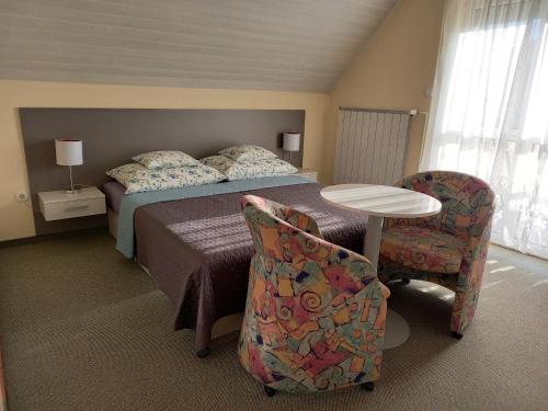 a bedroom with a bed and a table and chairs at Família Szabó Vendégház in Hévíz