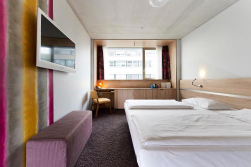 a hotel room with two beds and a desk at Simm's Hotel - cityhotel next to Metro U3 in Vienna