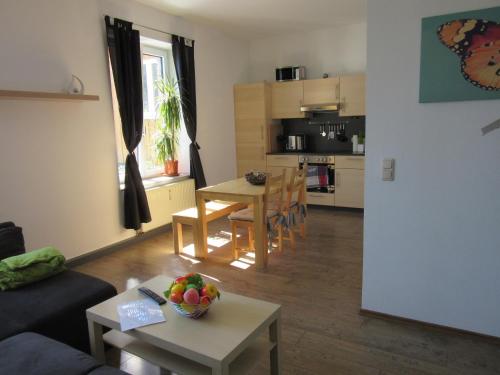 a living room with a couch and a table with a bowl of fruit at Ferienanlage Markus Nitsch in Bärenstein