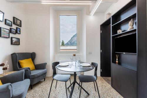 a living room with a table and chairs and a tv at Varenna amorevole dimora in Lecco in Lecco