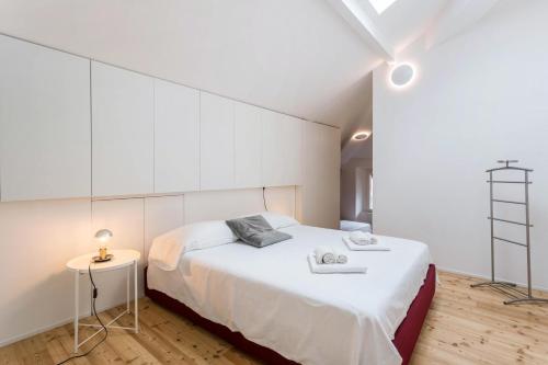 a bedroom with a white bed and a white wall at Varenna amorevole dimora in Lecco in Lecco