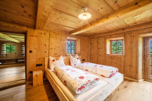 a bedroom with a bed in a room with wooden walls at Schnitzers Ferienheisl in San Leonardo in Passiria