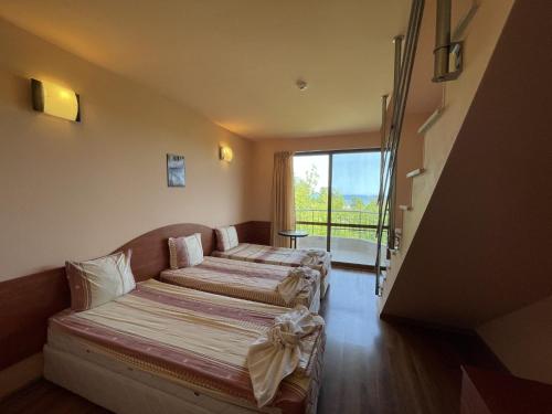 um quarto de hotel com duas camas e uma varanda em Hotel Vega em Kranevo