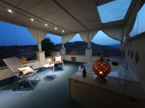 a room with a balcony with chairs and a table at Casale Di Benedetto in Caltagirone