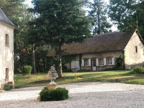 a stone house with a statue in front of it at The cosy retreat in Mornay-sur-Allier