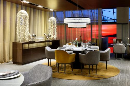 a dining room with a table and chairs at Hyatt Regency Barcelona Tower in Hospitalet de Llobregat
