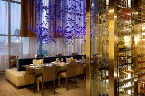 a restaurant with a table and chairs and a chandelier at Hyatt Regency Barcelona Tower in Hospitalet de Llobregat