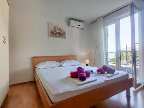 a bedroom with a large bed with purple pillows on it at Marios in Brela