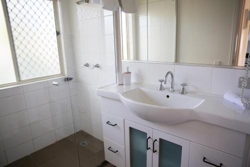 y baño blanco con lavabo y ducha. en 2 Bedroom Villa In Tropical Resort en Noosaville