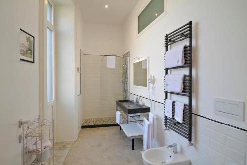 a white bathroom with a sink and a mirror at Palazzo Rollo in Lecce