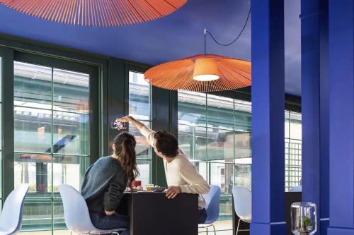 zwei Frauen an einem Tisch in einem Zimmer in der Unterkunft La suite new-yorkaise Disneyland Paris in Serris