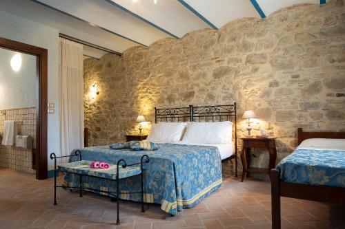 アッシジにあるAgriturismo Colle Puの石壁のベッドルーム1室(ベッド2台付)