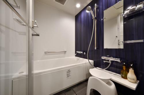 a bathroom with a shower and a toilet and a sink at Hotel Art Stay Naha Kokusai-Dori in Naha