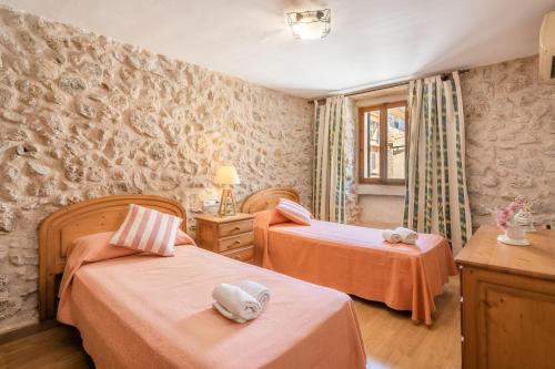 Un dormitorio con dos camas y una ventana. en Ca la Pradina, en Pollensa