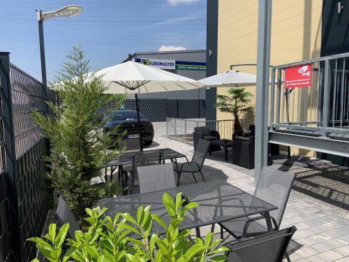 a patio with tables and chairs and umbrellas at Work & Sleep Boardinghouse Mannheim in Mannheim