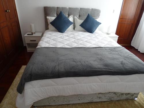 a bedroom with a large bed with blue pillows at Enchanted Villa in Tavira