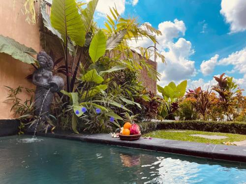 a statue of a monkey next to a swimming pool at Uma Jala Villa Ubud in Ubud