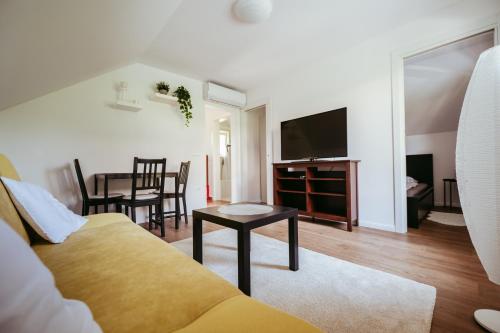 a living room with a couch and a tv and a table at Apartment Oddih in Bled
