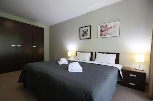a bedroom with a bed with two towels on it at Willa Port, apartament 204 in Ostróda