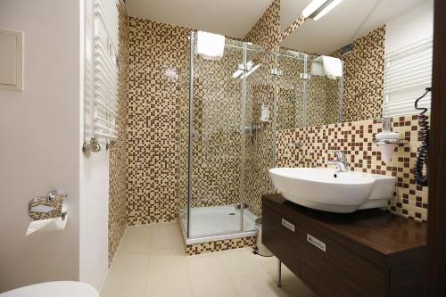 een badkamer met een wastafel en een douche bij Willa Port, apartament 204 in Ostróda
