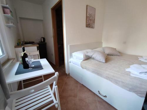 - une chambre avec un lit et une table avec une bouteille de vin dans l'établissement Private bedroom with bathroom, à Baška Voda