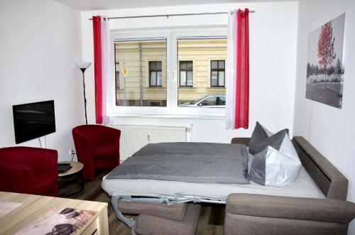 een kleine slaapkamer met een bed en een raam bij Ferienwohnung am Wasserturm in Zwenkau